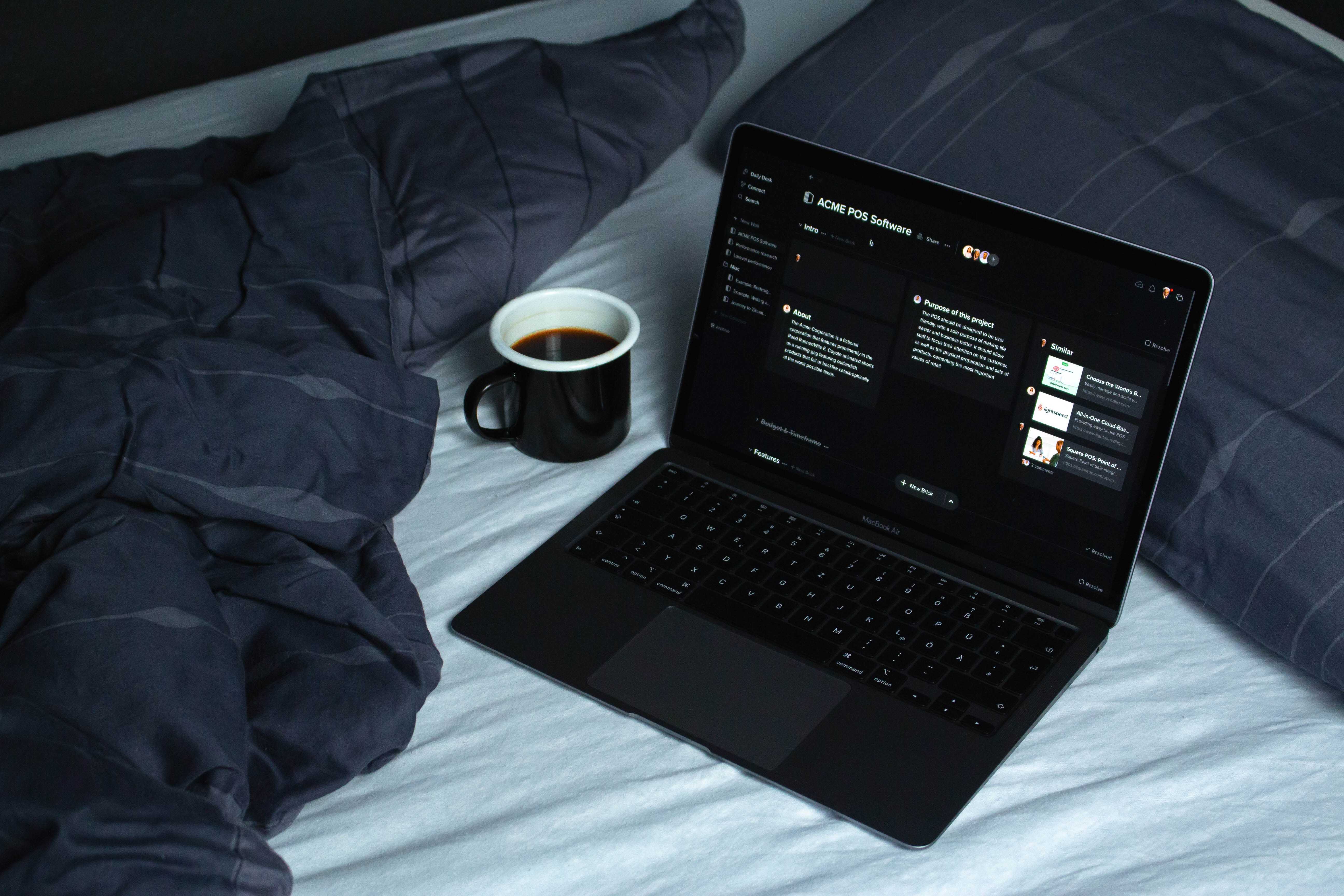 Laptop auf einem Bett, mit einer Kaffeetasse